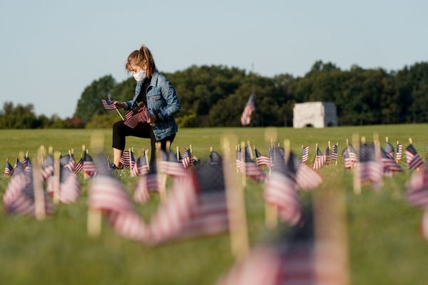 В США число погибших от коронавируса превысило 200 тысяч человек. На фото - молодая девушка в маске размещает флаги Соединенных Штатов в память о погибших от COVID-19 на Национальной аллее в Вашингтоне - Sputnik Азербайджан