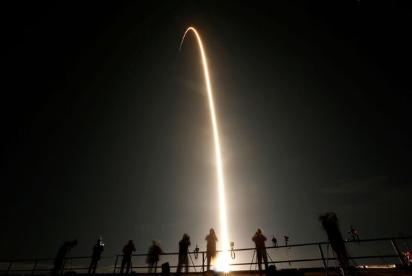 Люди наблюдают за запуском ракеты SpaceX Falcon 9 с капсулой Crew Dragon с четырьмя астронавтами в Космическом центре Кеннеди на мысе Канаверал, Флорида, США - Sputnik Азербайджан