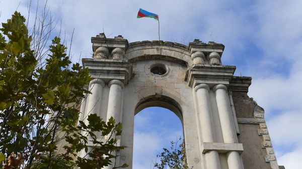 Флаг Азербайджана над разрушенным зданием в Физули, где раньше находилась редакция газеты Араз - Sputnik Азербайджан