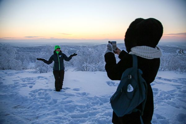 Девушка фотографируется во время встречи первого рассвета после полярной ночи на горе Солнечная в Мурманске - Sputnik Азербайджан