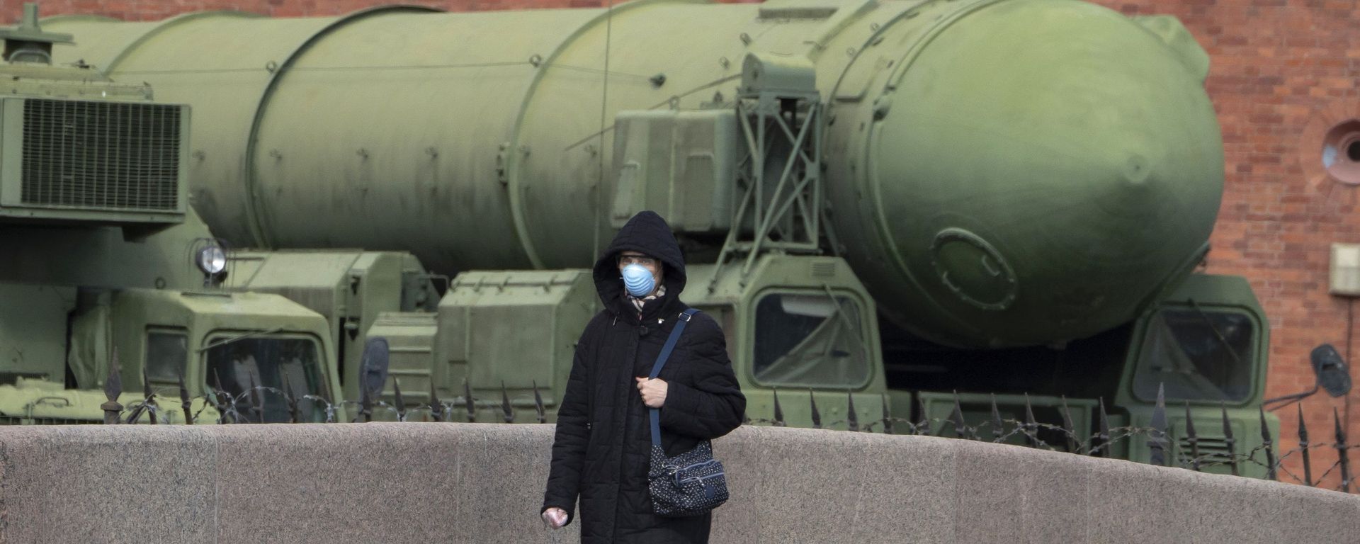 Женщина в маске проходит мимо российской межконтинентальной пусковой установки баллистических ракет «Тополь М», фото из архива - Sputnik Азербайджан, 1920, 10.12.2024