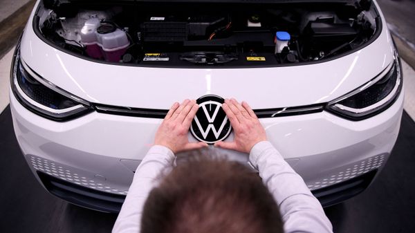 Рабочий устанавливает логотип VW на электромобиле Volkswagen ID.3 на сборочном конвейере автозавода Volkswagen - Sputnik Азербайджан