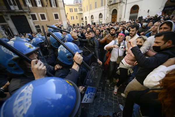 Полицейские используют дубинки против протестующих во время столкновений в рамках демонстрации владельцев малого бизнеса у здания парламента в Риме - Sputnik Азербайджан