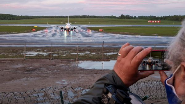 Женщина фотографирует посадку самолета авиакомпании Ryanair в Вильнюсе - Sputnik Азербайджан