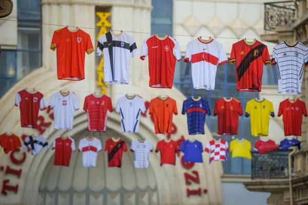 Люди проходят рядом с формами участников чемпионата Европы по футболу - Sputnik Азербайджан