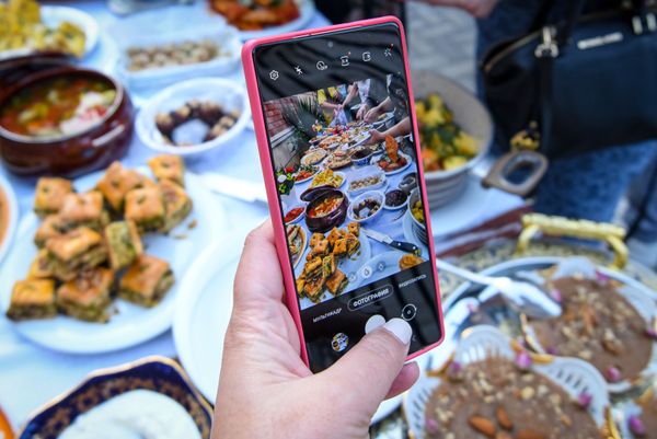 Посетитель фотографирует блюда на Неделе узбекской кухни в Азербайджане. - Sputnik Азербайджан