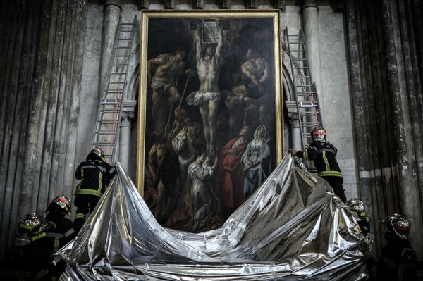 Французские пожарные накрывают картину огнестойким одеялом во время учений по сохранению произведений искусства, выставленных в соборе Сен-Андре в Бордо. - Sputnik Азербайджан