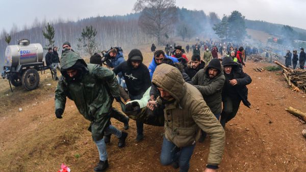 Мужчины несут к машине скорой помощи женщину в лагере нелегальных мигрантов на белорусско-польской границе - Sputnik Азербайджан