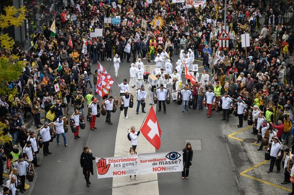 Протестующие держат флаги и транспаранты во время акции протеста в Лозанне, Швейцария. - Sputnik Азербайджан