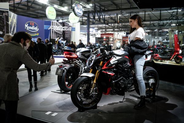 Мужчина фотографирует модель, представляющую мотоцикл MV Agusta на EICMA. - Sputnik Азербайджан