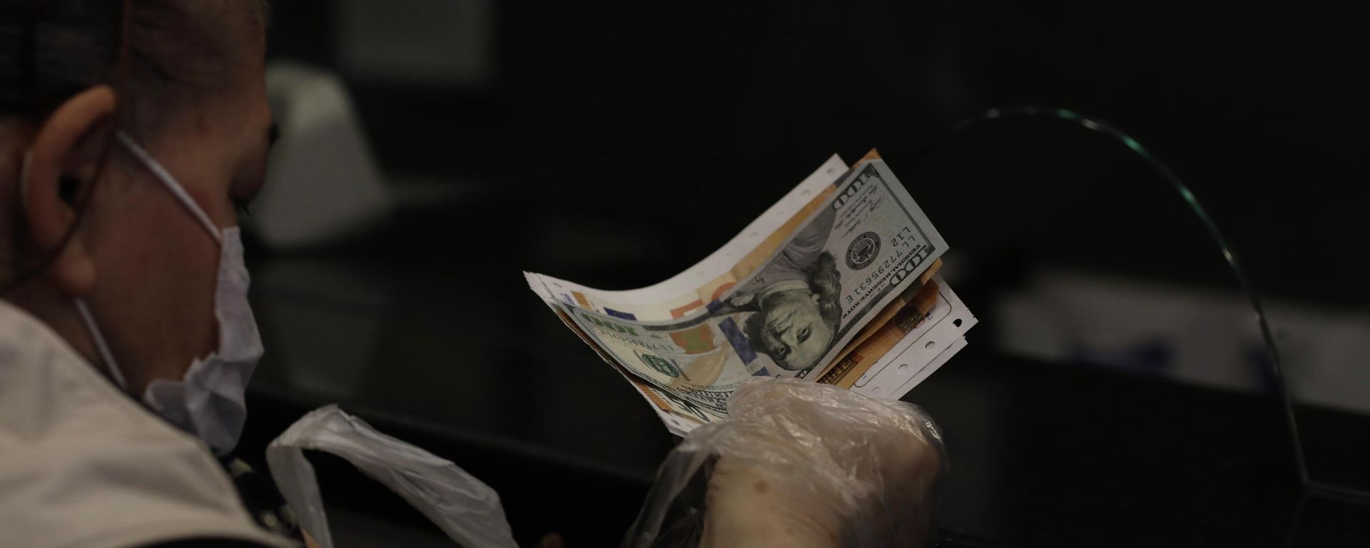 Женщина меняет турецкую лиру на доллары США и евро в пункте обмена валюты в Анкаре - Sputnik Азербайджан, 1920, 03.12.2021