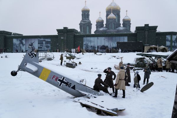 Российские солдаты, одетые в форму Красной Армии времен Второй мировой войны, разговаривают возле макета сбитого самолета нацистской Германии, готовясь принять участие в постановочном бою в честь 80-летия битвы за Москву в парке Патриот. - Sputnik Азербайджан