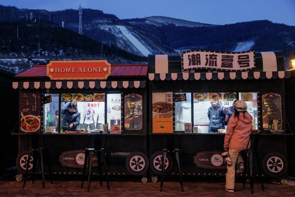 Женщина за продуктовым ларьком на горнолыжном курорте Тайву в Чжанцзякоу, недалеко от мест проведения зимних Олимпийских игр. - Sputnik Азербайджан