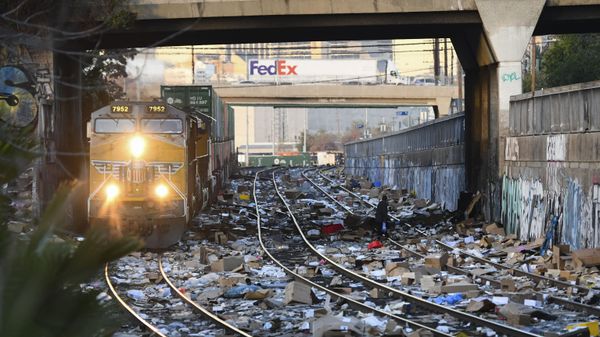 Локомотив Union Pacific проезжает через участок железнодорожных путей Union Pacific, усеянный тысячами открытых коробок и упаковок, украденных из грузовых транспортных контейнеров в центре Лос-Анджелеса, Калифорния - Sputnik Азербайджан