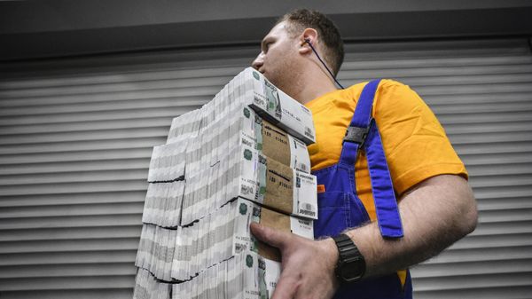 Рабочий несет пачки банкнот номиналом 1000 рублей на заводе Гознака в Москве - Sputnik Азербайджан