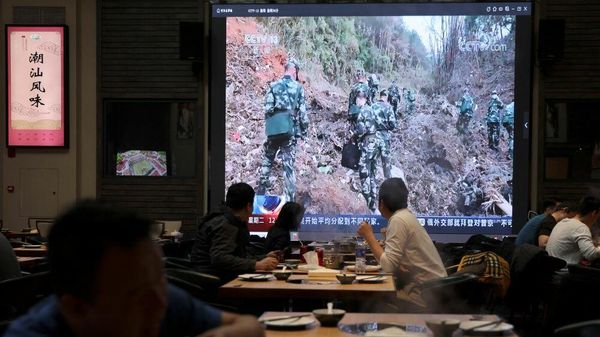 Экран, показывающий новостные кадры сотрудников военизированной полиции, работающих на месте крушения самолета Boeing 737-800 China Eastern Airlines в Пекине - Sputnik Азербайджан