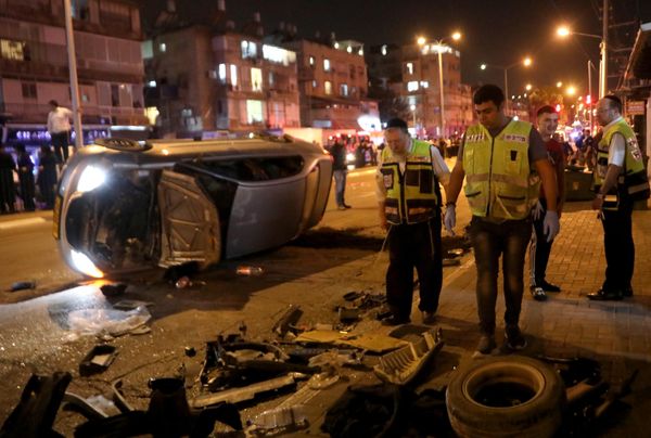 Перевернутый автомобиль лежит на дороге на месте обстрела в Бней-Браке. - Sputnik Азербайджан