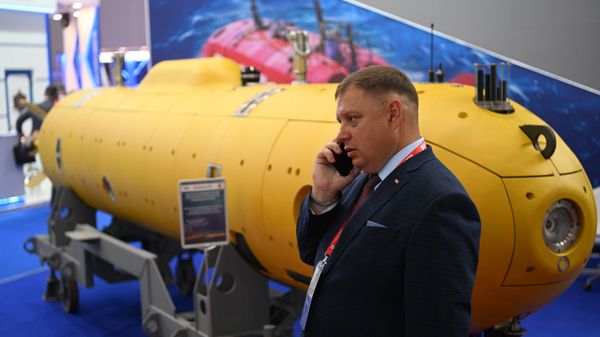 Посетитель разговаривает по телефону у модели подводной лодки на выставке в рамках Международного военно-технического форума Армия-2022 в Конгрессно-выставочном центре Патриот - Sputnik Азербайджан
