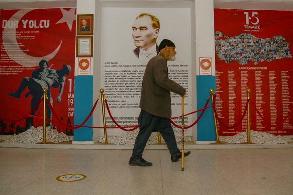 Мужчина проходит перед портретом Мустафы Кемаля Ататюрка на избирательном участке в Диярбакыре. - Sputnik Азербайджан