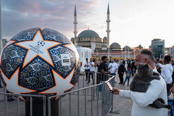 Мужчина фотографирует макет футбольного мяча Лиги чемпионов на площади Таксим в Стамбуле. - Sputnik Азербайджан