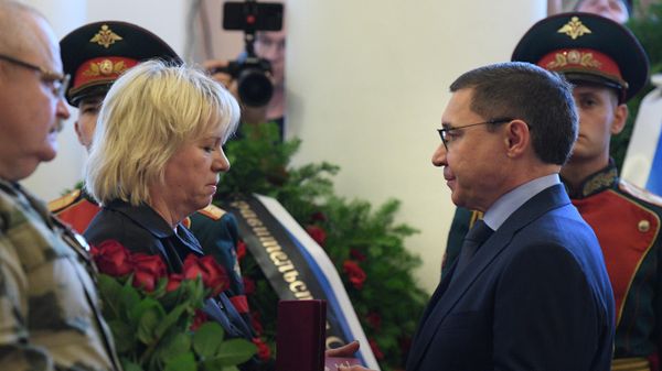 Полномочный представитель президента РФ в Уральском федеральном округе Владимир Якушев (справа) вручает матери Людмиле орден Мужества на церемонии прощания с погибшим в зоне СВО военным корреспондентом РИА Новости Ростиславом Журавлевым в Доме офицеров в Екатеринбурге - Sputnik Азербайджан