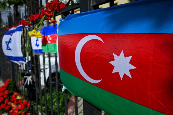 Люди несут цветы к израильскому посольству в Баку после атаки движения ХАМАС на Израиль. - Sputnik Азербайджан