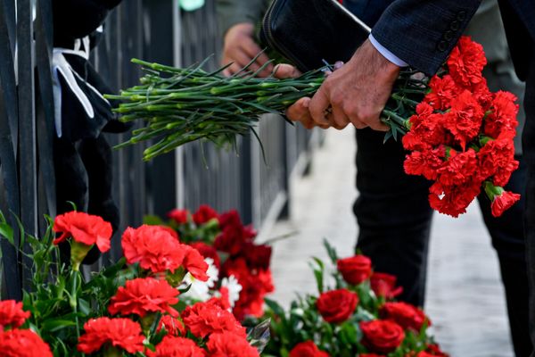 Люди несут цветы к израильскому посольству в Баку после атаки движения ХАМАС на Израиль. - Sputnik Азербайджан