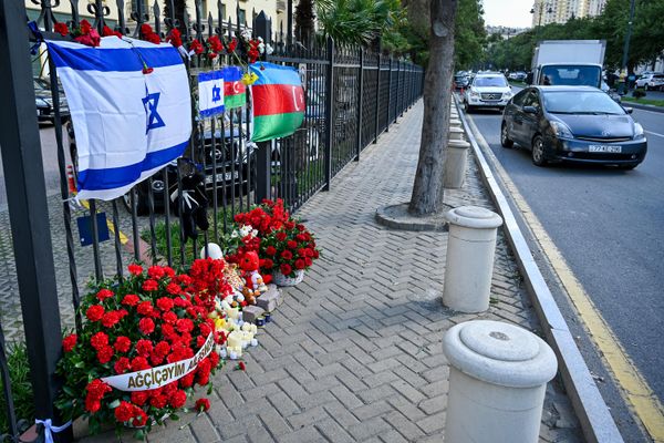 Люди несут цветы к израильскому посольству в Баку после атаки движения ХАМАС на Израиль. - Sputnik Азербайджан
