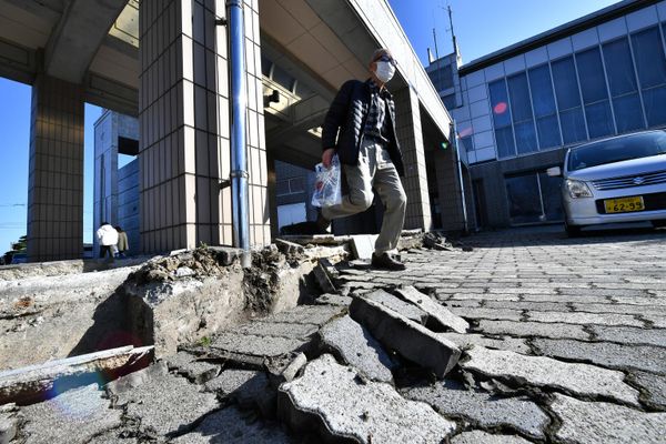 Мужчина проходит мимо выбитой брусчатки после землетрясения в городе Сики, Япония. - Sputnik Азербайджан