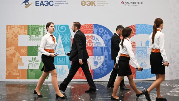  Участники проходят рядом со стендом с символикой Евразийского экономического форума - Sputnik Азербайджан