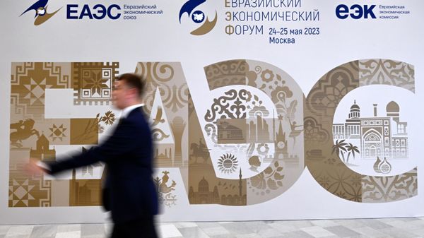  Участники проходят рядом со стендом с символикой Евразийского экономического форума - Sputnik Азербайджан