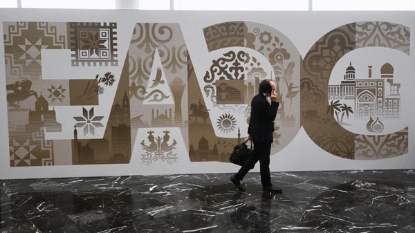 Участники проходят рядом со стендом с символикой Евразийского экономического форума - Sputnik Азербайджан