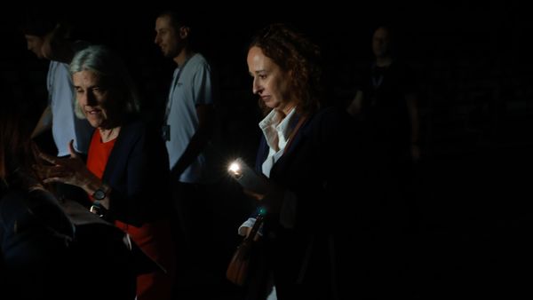 Люди используют свои телефонные фонарики, чтобы пройти по темным проходам во время общего отключения электроэнергии в седьмой день Mutua Madrid Open - Sputnik Азербайджан