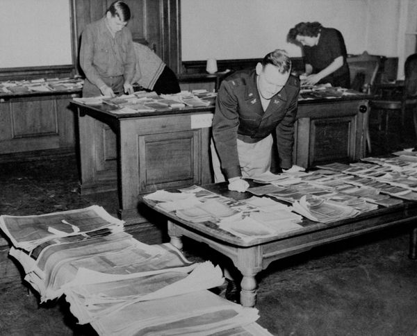 23 ноября 1945 года в комнате документации здания суда в Нюрнберге (Германия) лейтенант Роджер У. Барретт из Чикаго проверяет одни из сотен фотокопий оригинальных документов, которые используются в качестве доказательств обвинения против нацистских военных преступников на судебных процессах. (AP Photo) - Sputnik Азербайджан