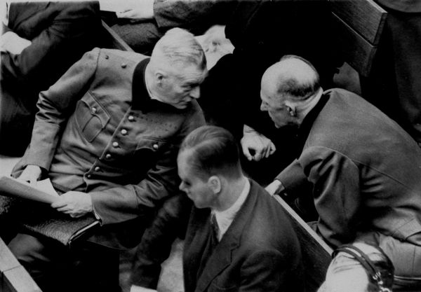 21 ноября 1945 года, во второй день судебных процессов в Нюрнберге (Германия), генерал Альфред Йодль (справа) и генерал Вильгельм Кейтель разворачиваются друг к другу, чтобы переговорить на скамье подсудимых.(AP Photo/Pool) - Sputnik Азербайджан