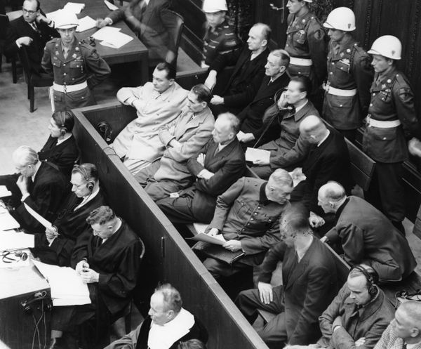 В ноябре 1945 года во время процесса над нацистскими военными преступниками во Дворце юстиции в Нюрнберге (Германия) фельдмаршал Вильгельм Кейтель (сидит в первом ряду четвертым слева) поворачивает голову, чтобы поговорить с генералом Альфредом Йодлем.(AP Photo) - Sputnik Азербайджан