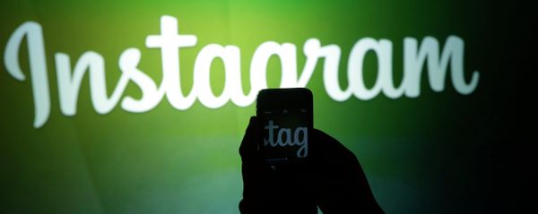 A journalist makes a video of the Instagram logo - Sputnik Азербайджан