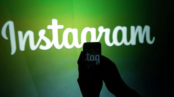 A journalist makes a video of the Instagram logo - Sputnik Азербайджан