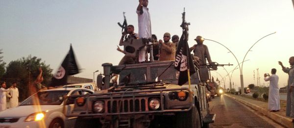 In this file photo taken Monday, June 23, 2014, fighters from the Islamic State group parade in a commandeered Iraqi security forces armored vehicle down a main road at the northern city of Mosul, Iraq. - Sputnik Азербайджан