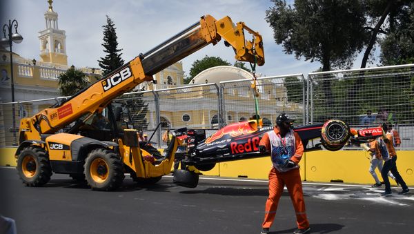 Кран поднимает автомобиль австралийского водителя Red Bull Racing Даниэля Риккардо после аварии на Бакинской городской трассе - Sputnik Азербайджан