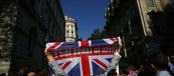 Житель Лондона держит в руках флаг Великобритании с надписью Проголосуй за выход из ЕС Житель Лондона держит в руках флаг Великобритании с надписью Проголосуй за выход из ЕС - Sputnik Азербайджан