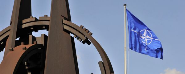 Эмблема и флаг НАТО перед зданием Альянса в Брюсселе - Sputnik Азербайджан