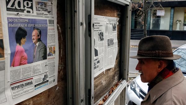 Мужчина за чтением утренних газет в Кишиневе, Молдова, 31 октября 2016 года - Sputnik Азербайджан