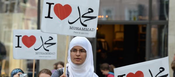 Женщина во время акции в поддержку мусульман держит плакат с надписью Я люблю Мухаммеда, Германия, Гамбург, 29 сентября 2012 года - Sputnik Азербайджан