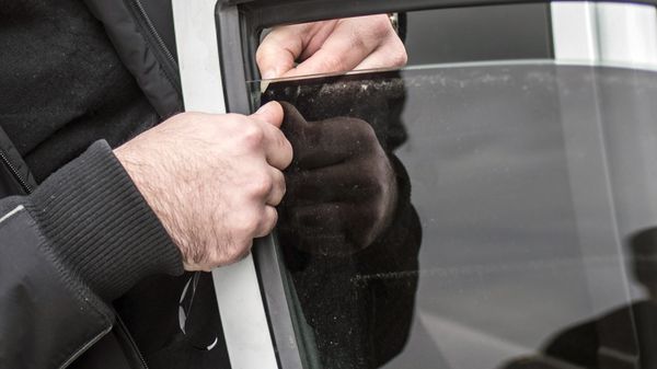 Автовладелец снимает тонировочную пленку со стекла своего автомобиля, фото из архива - Sputnik Азербайджан