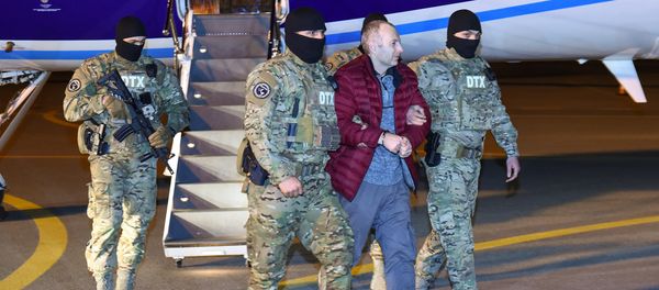 Российско-израильский блогер Александр Лапшин в сопровождении сотрудников Генпрокуратуры - Sputnik Азербайджан