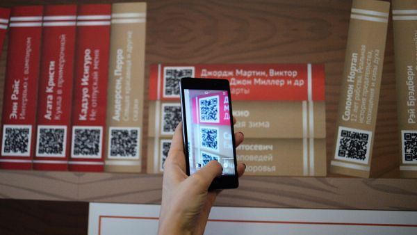 Девушка сканирует QR-код на презентации проекта Мобильные библиотеки, фото из архива - Sputnik Азербайджан
