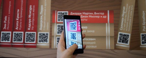 Девушка сканирует QR-код на презентации проекта Мобильные библиотеки, фото из архива - Sputnik Азербайджан