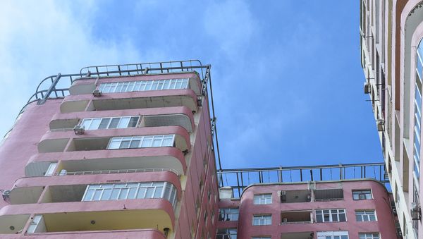 Многоэтажный дом с двухъярусной мансардой, металлическое листовое покрытие которой снес ветер - Sputnik Азербайджан