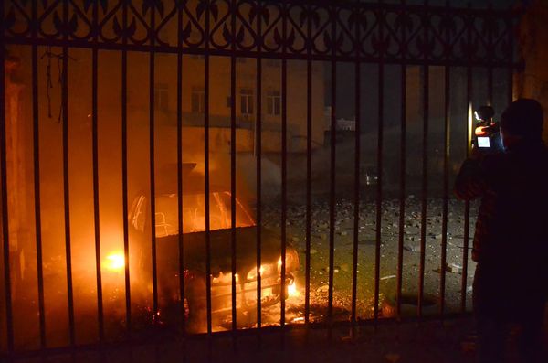 Оператор одного из грузинских телеканалов снимает сожженную в ходе беспорядков в Батуми машину - Sputnik Азербайджан